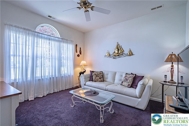 living area featuring a ceiling fan, carpet, and baseboards