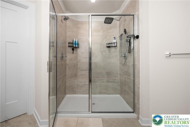 full bath with tile patterned flooring, a shower stall, and baseboards
