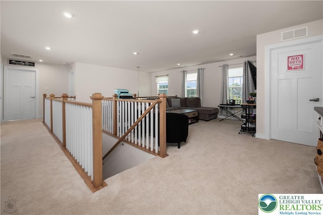 corridor featuring an upstairs landing, light colored carpet, and recessed lighting