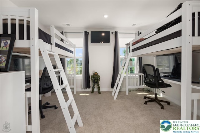 carpeted bedroom featuring a desk and baseboards