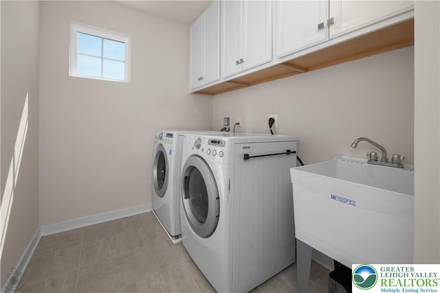 clothes washing area with cabinet space, independent washer and dryer, and baseboards