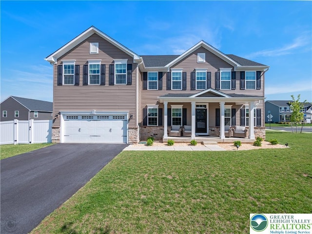 view of front of house featuring stone siding, covered porch, and driveway