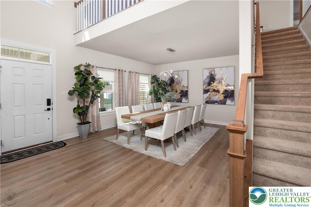 dining space featuring wood finished floors, stairway, and baseboards
