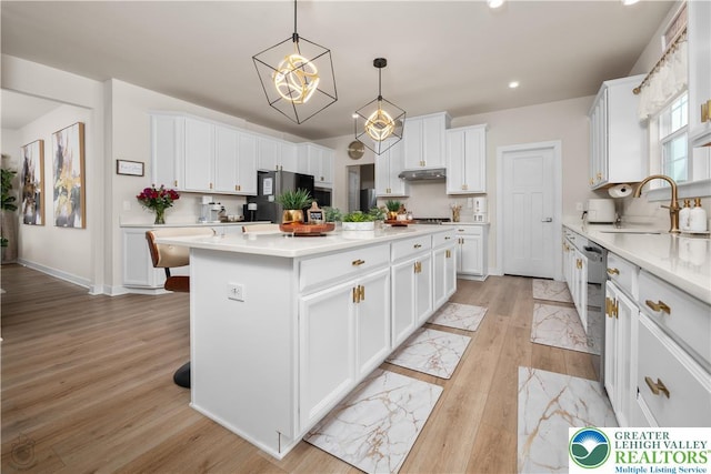 kitchen with a sink, appliances with stainless steel finishes, a center island, white cabinets, and recessed lighting