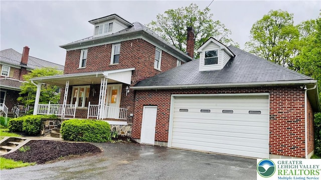 view of front of property with brick siding, driveway, a porch, a garage, and roof with shingles