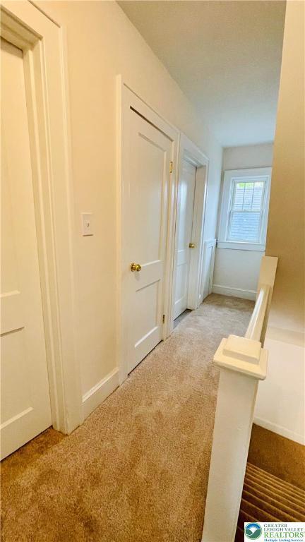 hallway with carpet and baseboards