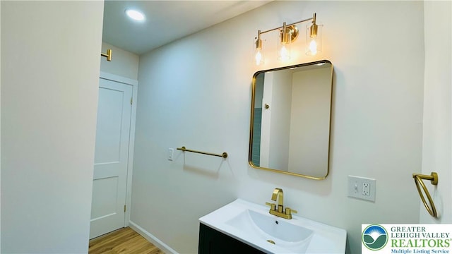 bathroom featuring wood finished floors, vanity, and baseboards