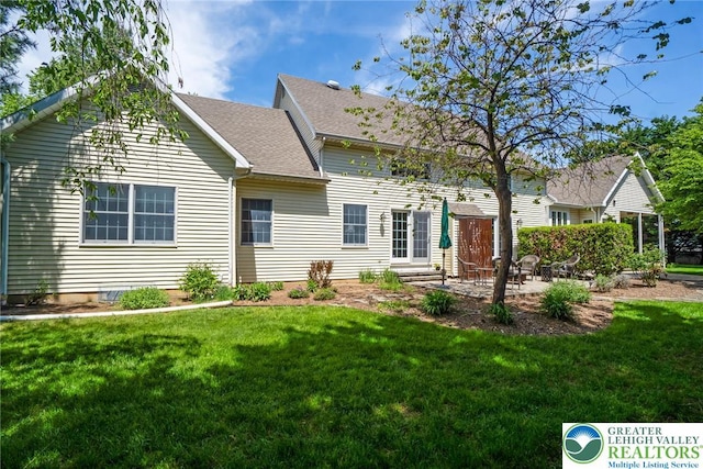 rear view of property featuring a patio, a lawn, and a shingled roof