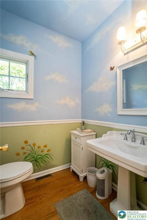 bathroom featuring wood finished floors and toilet
