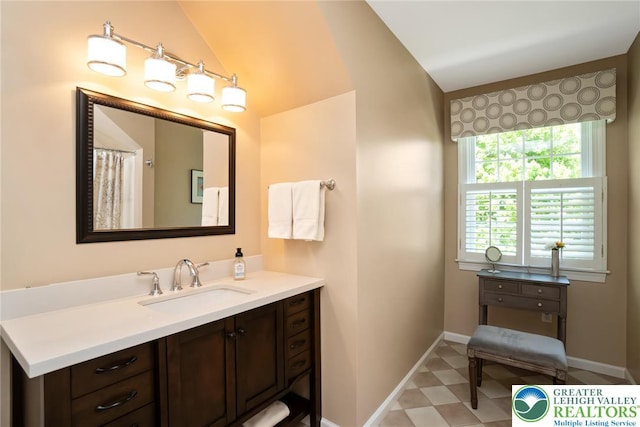 full bath featuring lofted ceiling, baseboards, vanity, and tile patterned floors