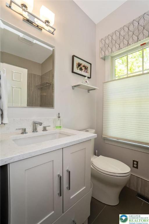 bathroom with vanity, tile patterned flooring, and toilet