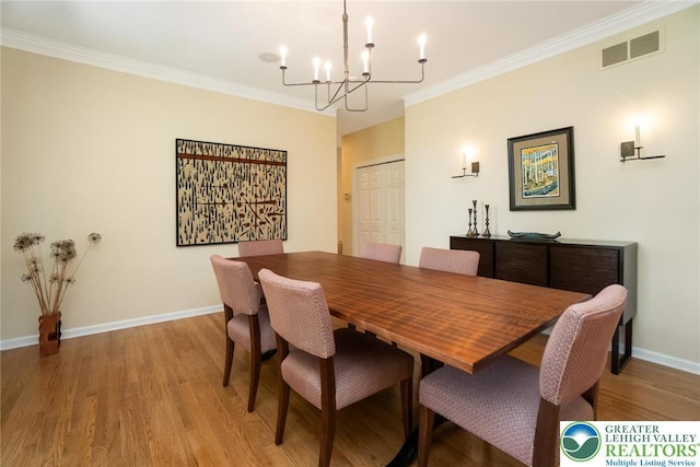 dining area featuring a chandelier, light wood-type flooring, ornamental molding, and baseboards