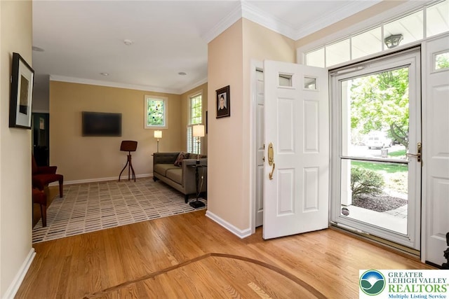 entrance foyer with light wood finished floors, baseboards, and crown molding