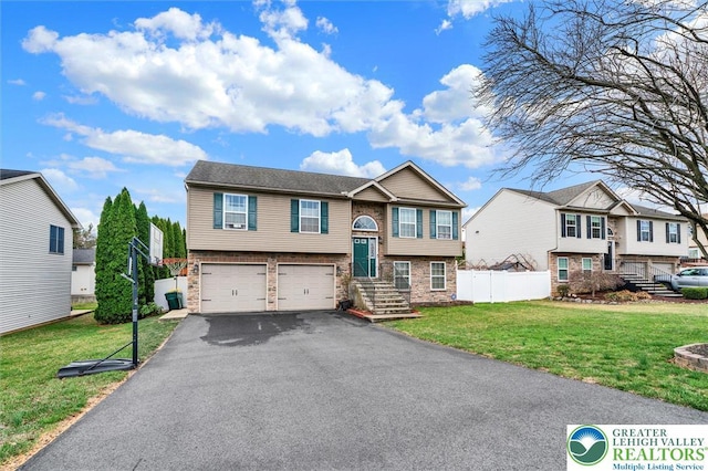 split foyer home with asphalt driveway, an attached garage, a residential view, stone siding, and brick siding