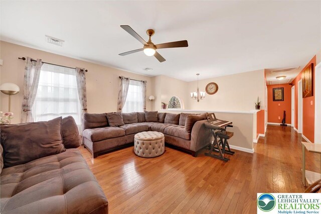 living room with ceiling fan, hardwood / wood-style floors, attic access, and baseboards