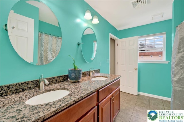 full bathroom featuring tile patterned floors, double vanity, and baseboards