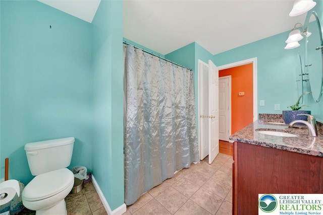full bath with tile patterned flooring, vanity, and toilet