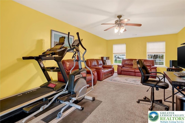 carpeted home office featuring a ceiling fan