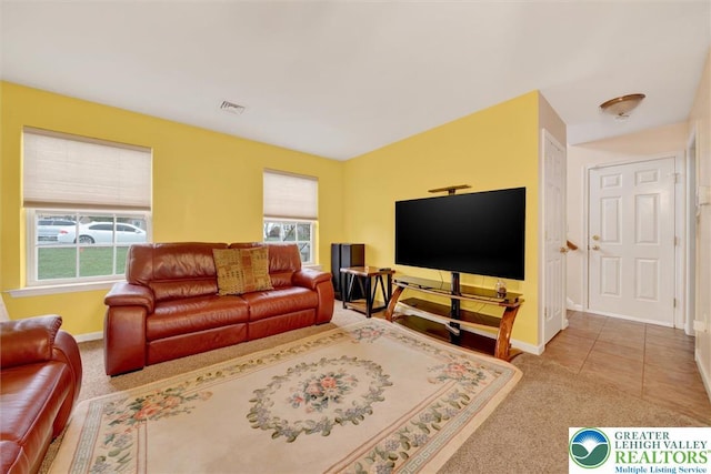 living room featuring healthy amount of natural light, baseboards, and carpet flooring