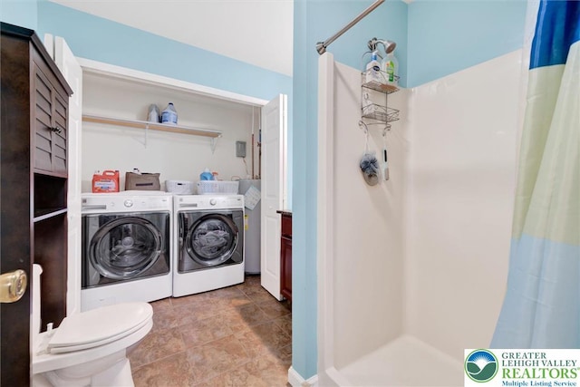 full bath with independent washer and dryer, curtained shower, toilet, and stone finish floors
