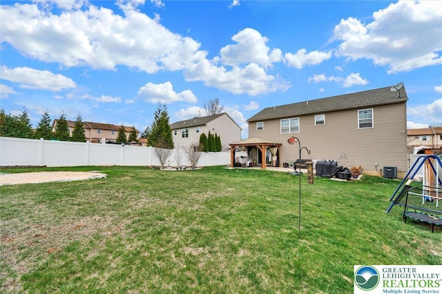 back of property with a gazebo, a patio area, a playground, and central AC