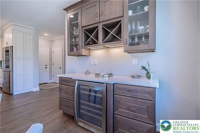indoor dry bar with wine cooler, stainless steel fridge, dark wood finished floors, crown molding, and recessed lighting