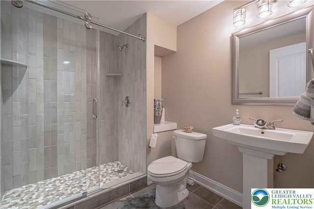 full bathroom featuring tile patterned flooring, toilet, a shower stall, and baseboards