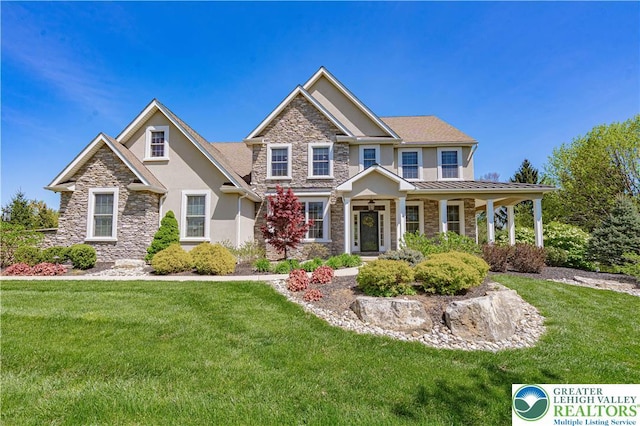 craftsman inspired home featuring stone siding, stucco siding, and a front lawn