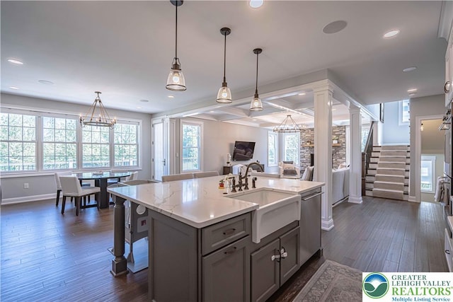 kitchen featuring stainless steel dishwasher, baseboards, open floor plan, a sink, and dark wood finished floors