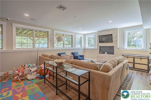 living area featuring healthy amount of natural light, wood finished floors, a fireplace, and recessed lighting