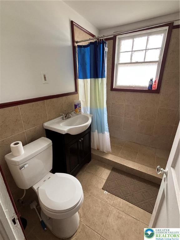 330 18th St, Allentown City, PA 18104 - full bathroom with toilet, tile walls, vanity, a tile shower, and tile patterned floors
