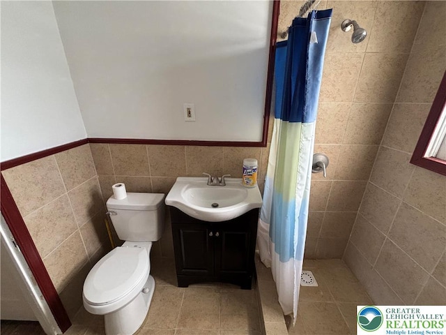 330 18th St, Allentown City, PA 18104 - full bathroom featuring a shower stall, toilet, vanity, tile walls, and a wainscoted wall