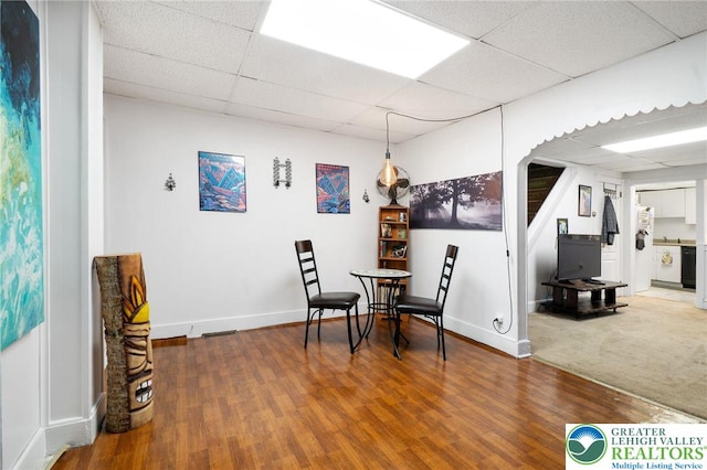 dining room featuring a paneled ceiling, wood finished floors, baseboards, and arched walkways