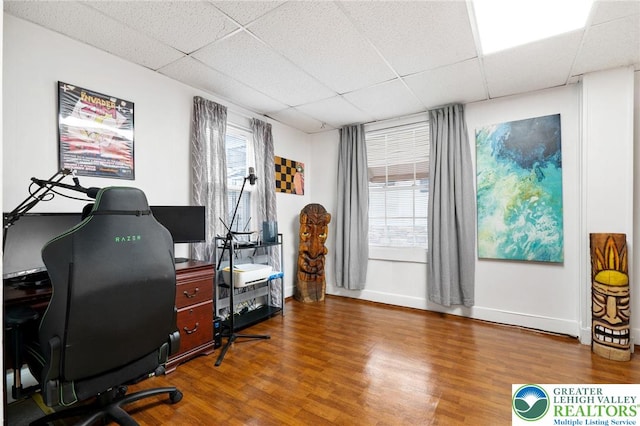 office with a paneled ceiling, wood finished floors, and baseboards