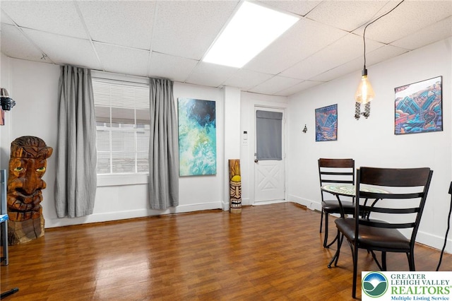 dining room featuring a paneled ceiling, wood finished floors, and baseboards