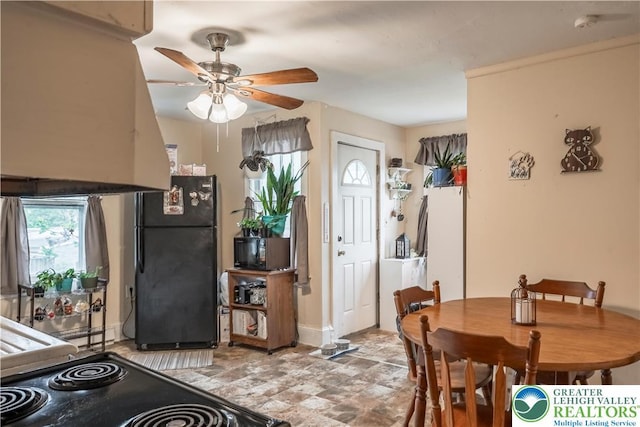 dining area with a ceiling fan and baseboards