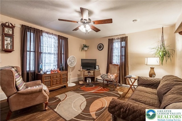 living room with wood finished floors, ceiling fan, and baseboards