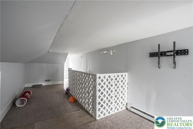 additional living space featuring baseboard heating, vaulted ceiling, and baseboards