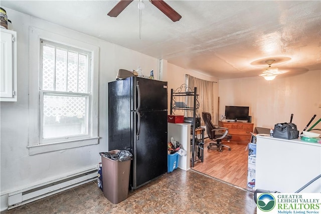 kitchen with freestanding refrigerator, baseboard heating, a ceiling fan, an office area, and white cabinetry