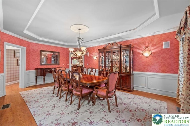 217 Rising Meadow Way, Middle Smithfield Twp, PA 18302 - dining room featuring a raised ceiling, wallpapered walls, a chandelier, wainscoting, and light wood finished floors