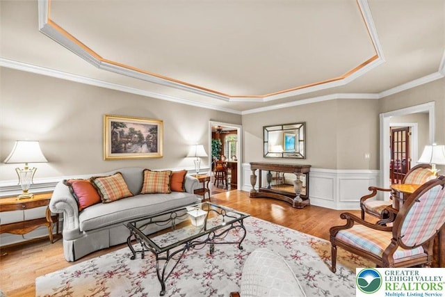217 Rising Meadow Way, Middle Smithfield Twp, PA 18302 - living room with a tray ceiling, wood finished floors, a wainscoted wall, and crown molding