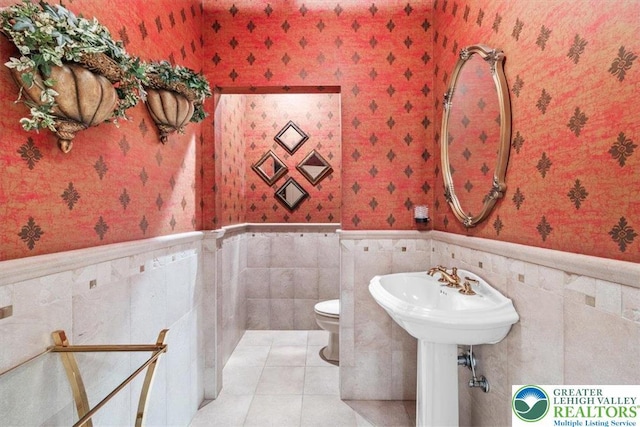 217 Rising Meadow Way, Middle Smithfield Twp, PA 18302 - bathroom featuring wallpapered walls, a wainscoted wall, toilet, tile patterned flooring, and tile walls