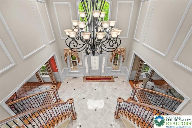 217 Rising Meadow Way, Middle Smithfield Twp, PA 18302 - foyer entrance featuring plenty of natural light, a chandelier, a towering ceiling, a decorative wall, and stairs