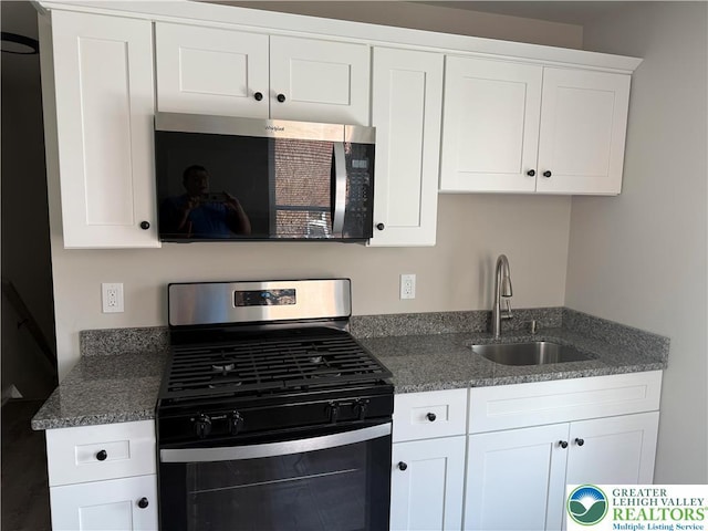 1107 Lehigh St, Easton, PA 18042 - kitchen with appliances with stainless steel finishes, a sink, white cabinets, and dark stone counters