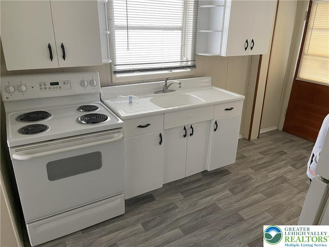 kitchen featuring electric range, light countertops, white cabinets, open shelves, and a sink