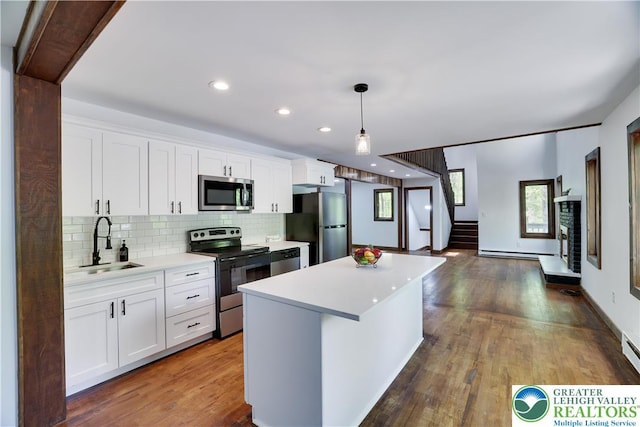 8210 Pine Grove, Stroud Twp, PA 18301 - kitchen with appliances with stainless steel finishes, a sink, light countertops, a center island, and decorative backsplash