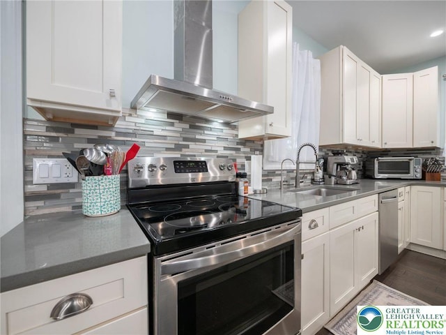 1942 Schadt Ave, Whitehall Twp, PA 18052 - kitchen featuring stainless steel appliances, wall chimney exhaust hood, a sink, white cabinets, and tasteful backsplash
