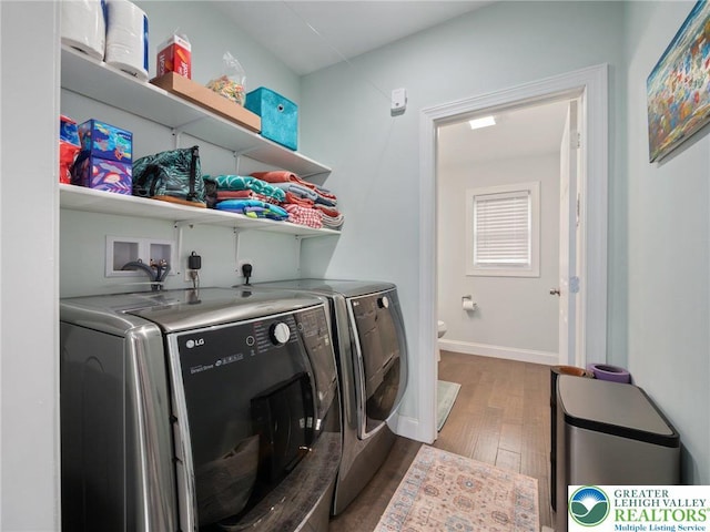 clothes washing area featuring washer and dryer, dark wood-style floors, and baseboards
