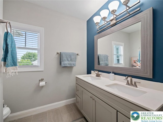1942 Schadt Ave, Whitehall Twp, PA 18052 - bathroom featuring a chandelier, baseboards, toilet, and double vanity