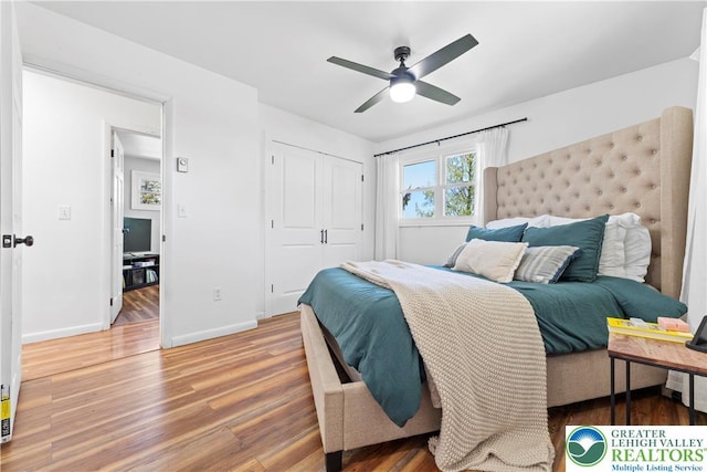 bedroom featuring wood finished floors, baseboards, a closet, and ceiling fan